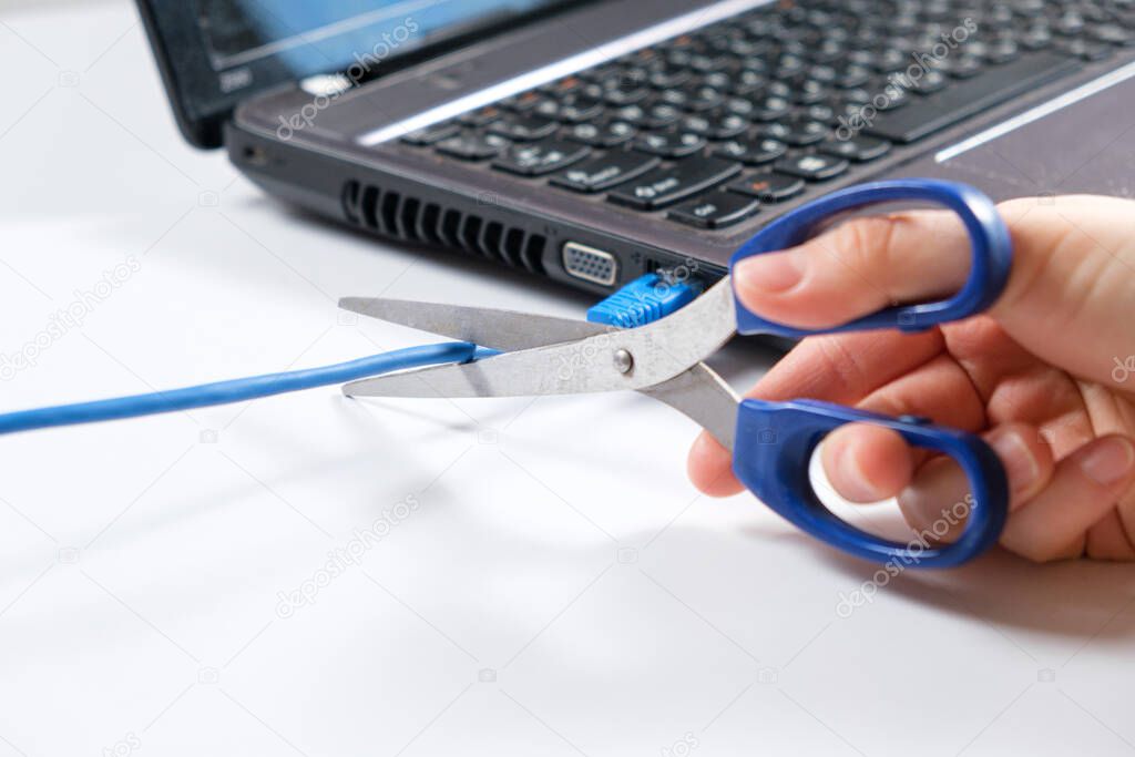 Scissors cut the Internet cable connected to the laptop. Turning off the internet, wi-fi