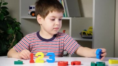 4 yaşındaki bir çocuk saymayı öğrenir, sayının çok renkli figürlerini düzenler.