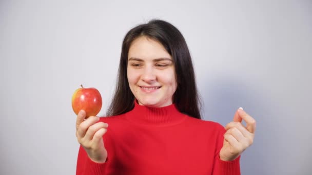 女人选择吃什么苹果或含有维生素的药丸 吃药丸 指着舌头微笑 营养补充剂和顺势疗法 — 图库视频影像