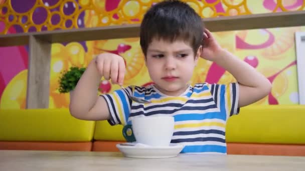 Een Jarige Jongen Een Gestreept Shirt Drinkt Cacao Van Een — Stockvideo