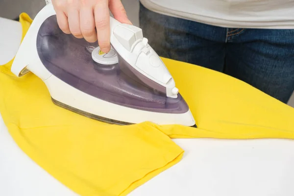 Eine Hausfrau Bügelt Ein Gelbes Shirt Mit Einem Bügeleisen Kleidung — Stockfoto