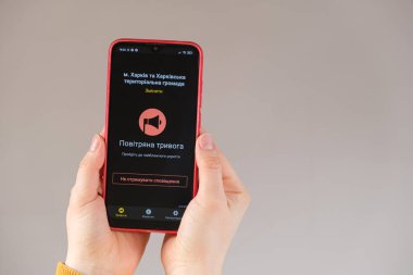 21 Mart 2022, Harkov, Ukrayna. Tehlike alarmı uygulaması aktif olan birinin elindeki bir akıllı telefon. Tercümesi Ukraynaca - Hava Alarmı