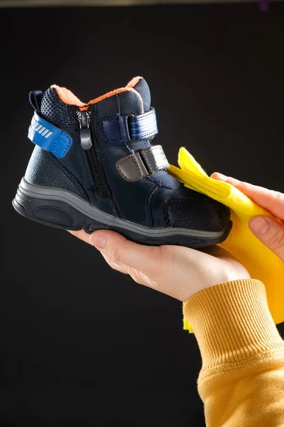 배경에 헝겊으로 아이의 신발을 닦는다 먼지를 아이들의 신발을 손질하는 — 스톡 사진