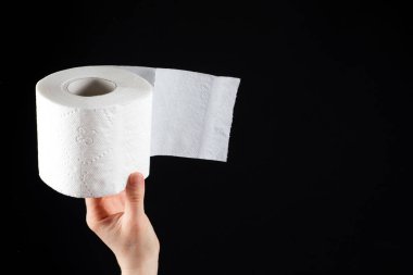 Bir erkeğin elindeki beyaz, yumuşak tuvalet kağıdı. Siyah bir arkaplan üzerinde el yazısı için yer var.