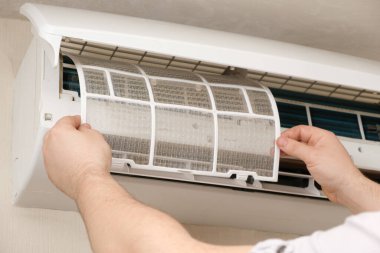 Usta temizlendikten sonra temiz bir klima filtresi takar. Klimaların bakımı, toz temizleme.