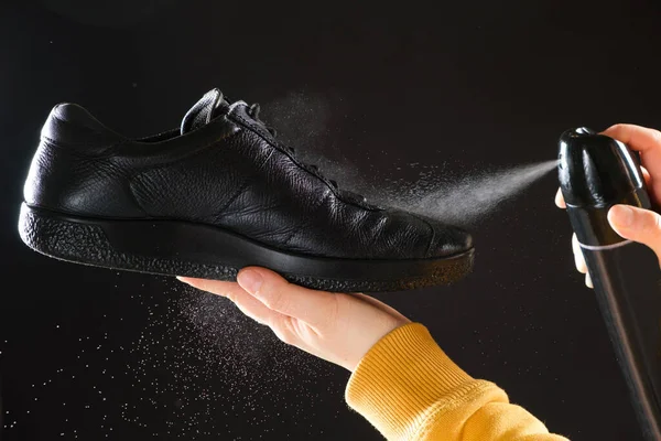 O processo de aplicação de um spray repelente de água para homens pretos sapatos de couro demi-temporada — Fotografia de Stock