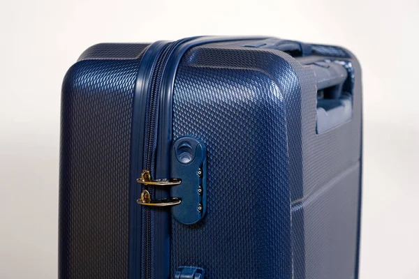 Combination lock and blocked zippers on a blue travel suitcase on a white background close-up. Travel safety. — ストック写真