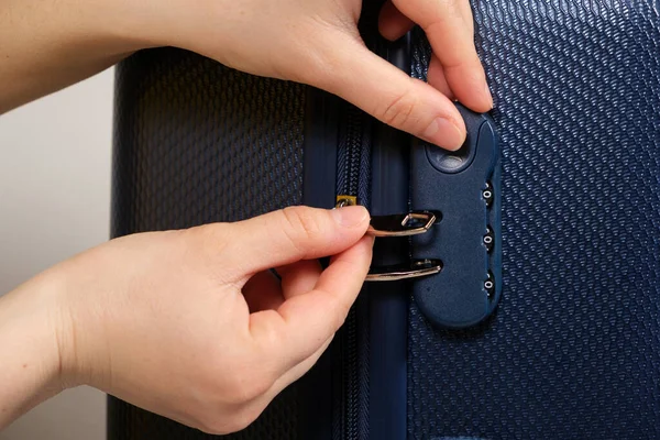 Bavulda bir el ve şifreli kilit var. Fermuar sürgülü kilit, yakın plan..