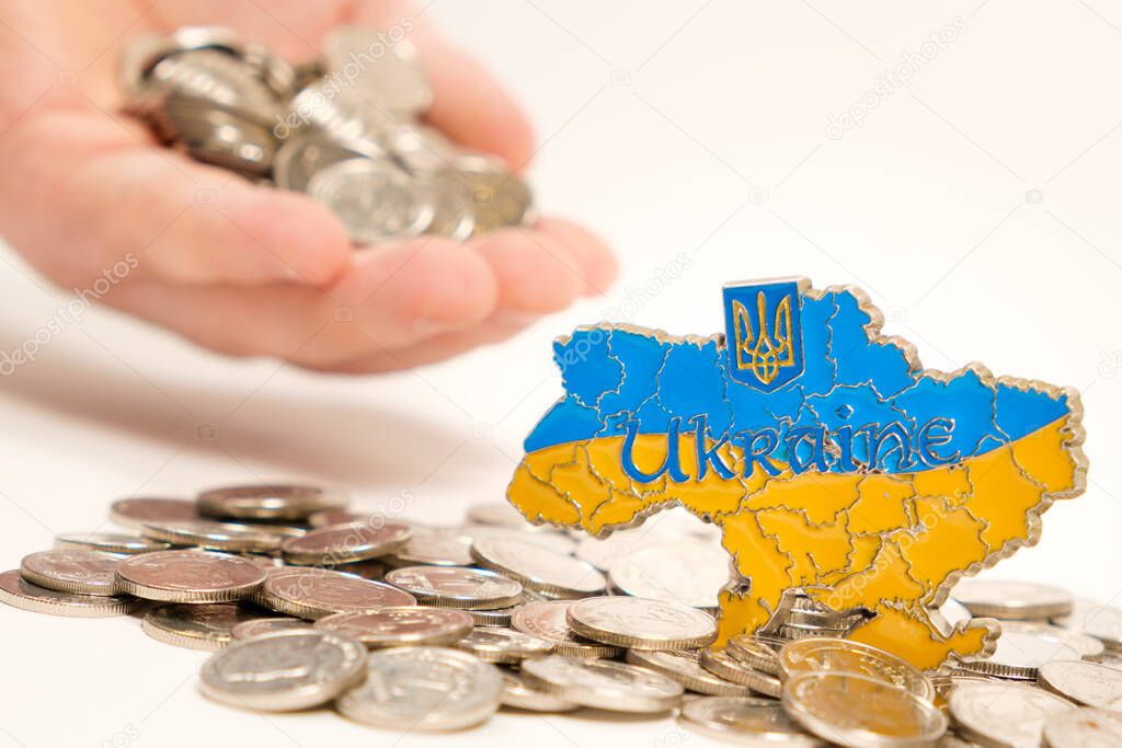 Ukraine and money, hand stretches out a handful of coins. International assistance to Ukraine, investment and business.