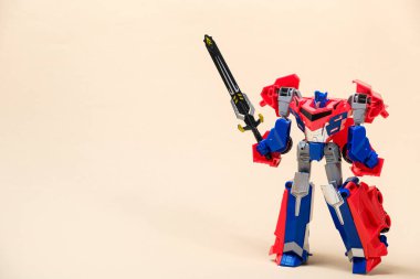 Bej bir zemin üzerinde kırmızı ve mavi bir robot transformatör ve metin için yer var. Çocuklar için oyuncaklar, oyuncakçılar..