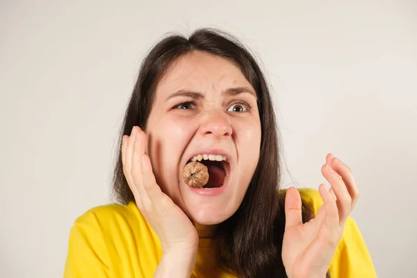 Bir kadın cevizi kemirir, ağzını sonuna kadar açar, dişini kırar ya da temporomandibular eklem yerinden çıkar, çenesi hareket eder..