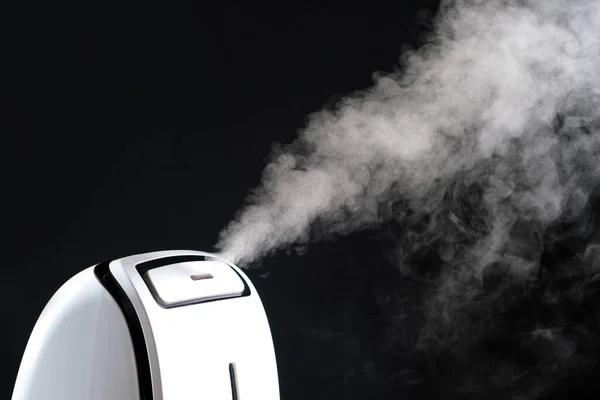 Humidifier with steam jet on a black background. Humidity in the room, maintaining the microclimate in the apartment. — 스톡 사진