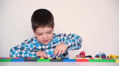 Preschool boy 4 years old plays with cars and toys, games for children, toy store on a white background.