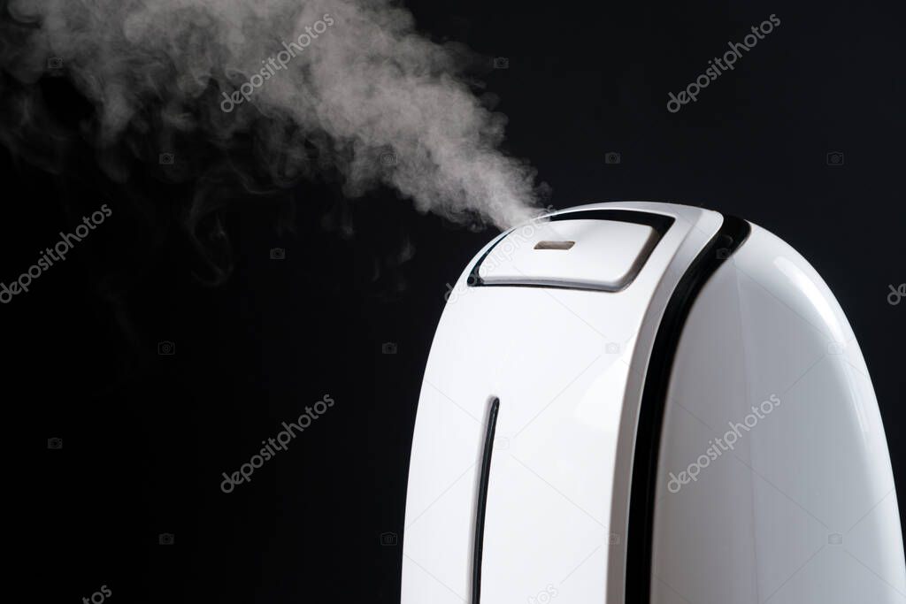 Humidifier with steam jet on a black background. Humidity in the room, maintaining the microclimate in the apartment.