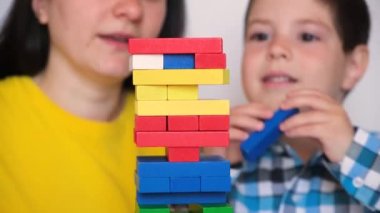Anne ve oğlu, renkli blokları kulenin dışına iterek Jenga oyunu oynuyorlar. 14 Mayıs 2022, Zaporozhye, Ukrayna.