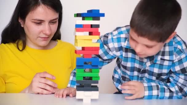 A mother and son play a board game of jenga, the tower falls. May 14 2022, Zaporozhye, Ukraine. — стоковое видео