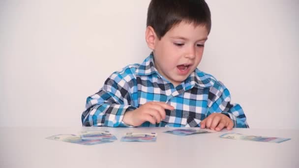 A 4-year-old boy counts money, holds euros in his hands. Teaching children financial literacy, pocket money. — Αρχείο Βίντεο