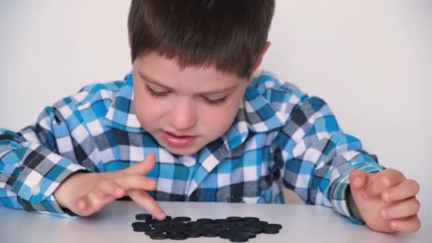 Un garçon de 4 ans apprend à compter, enseignant des puces numériques noires pour les enfants d'âge préscolaire — Video