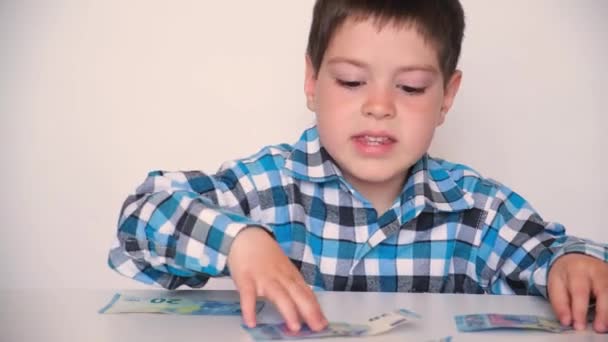 Čtyřletý chlapec počítá peníze, v rukou drží eura. Výuka finanční gramotnosti dětí, kapesné. — Stock video