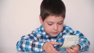4 yaşındaki bir çocuk para sayıyor, avroyu elinde tutuyor. Çocuklara finansal okuma yazma öğretmek, cep harçlığı.