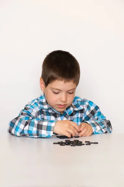 A 4-year-old boy is learning to count, teaching black numeracy chips for preschoolers — Stock fotografie