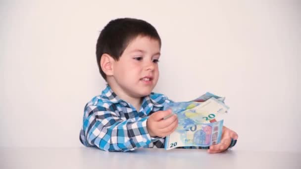 A 4-year-old boy counts money, holds euros in his hands. Teaching children financial literacy, pocket money. — Stockvideo