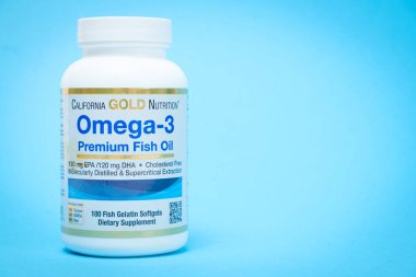 Bir kavanoz omega 3 balık yağı kapsülü mavi arka planda ve yazı için yeri var. 19 Mayıs 2022, Ukrayna, Zaporozhye.