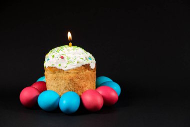 Paskalya pastası ve siyah bir zemine boyanmış yumurtalar, yazı için yer, Paska 'da mum.