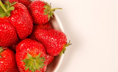 Beyaz arkaplanda sulu kırmızı çilekler, metin için yer var, yukarıdan yakın plan görünüm