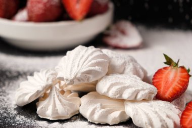 Kremalı pasta yakın plan ve siyah arka planda çilekler. Meyve tatlısı