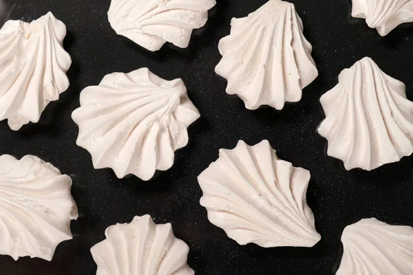 stock image White meringues on a black background, sweet pastries, a dessert of sugar and egg white