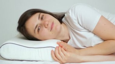 Bir kadın en sevdiği ortopedik yastığıyla yatağa girer, gülümser, gözlerini kapatır ve uykuya dalar.