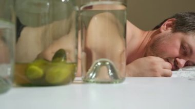Sarhoş bir adam ellerini başının üstüne koyarak yatakta uzanıyor. Akşamdan kalma, alkolik sayıklıyor..