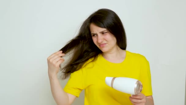 Seorang Wanita Berambut Cokelat Mengeringkan Rambutnya Dengan Pengering Rambut Melihat — Stok Video