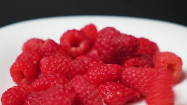 Raspberries Fall White Plate Black Background Side View Slow Motion — Vídeos de Stock