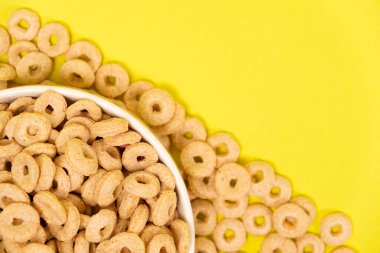 Sarı arka planda tabakta halka şeklinde hızlı kahvaltı..