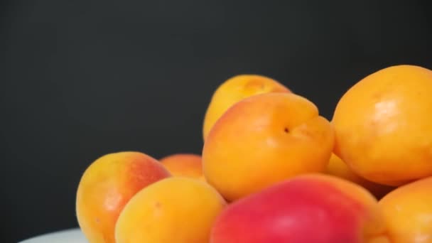 Abricots Mûrs Sur Une Assiette Tourner Cercle Sur Fond Noir — Video