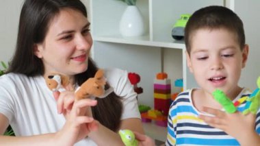 Mother and son play finger theater, toys on fingers