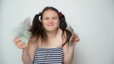 A funny woman dances holding a lot of money in her hands, throws money up.