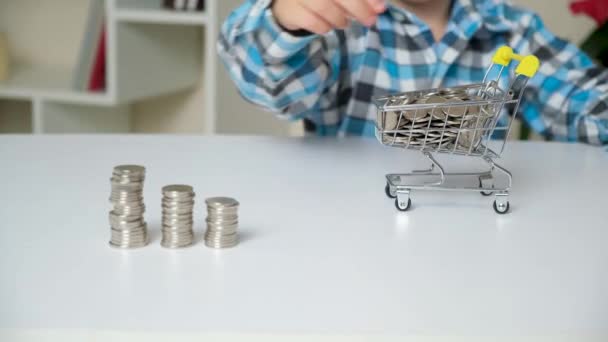 Boy Puts Coins Cart Points His Finger Towers Coins — Vídeo de Stock