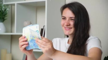 The woman counts the bills for twenty euros and smiles.