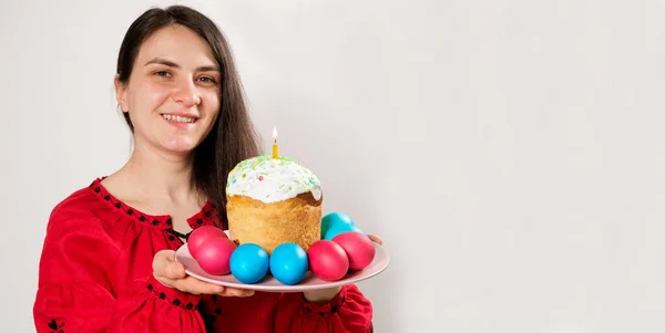 一个女人拿着复活节蛋糕 把彩蛋涂在白色的背景上 横幅上标明文字的位置 — 图库照片