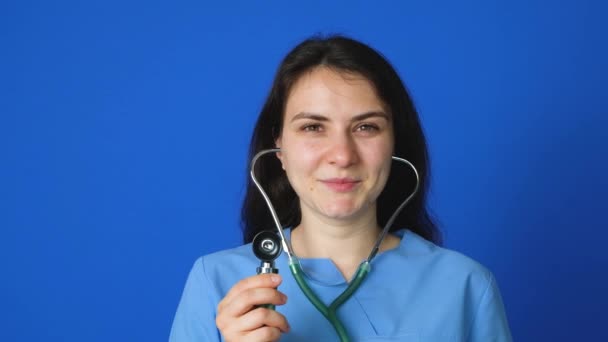 Medico Infermiere Con Uno Stetoscopio Sorride Uno Sfondo Blu — Video Stock