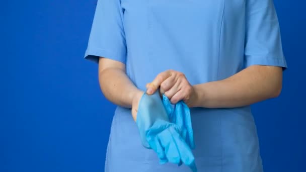 Médico Enfermeira Coloca Luvas Proteção Suas Mãos Sobre Fundo Azul — Vídeo de Stock