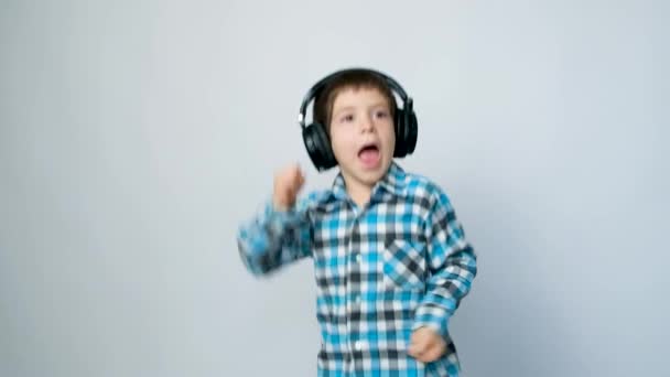 Річний Хлопчик Навушниках Стрибає Руками Вгору Білому Тлі — стокове відео