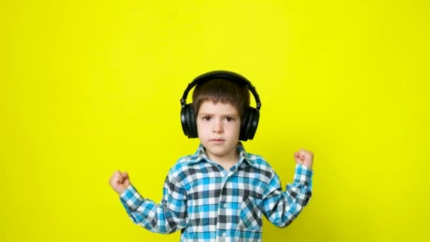 Щасливий Хлопчик Навушниках Стрибає Рахує Або Співає Жовтому Тлі — стокове відео