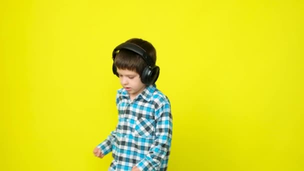 Річний Хлопчик Навушниках Плетена Сорочка Обертається Жовтому Тлі — стокове відео