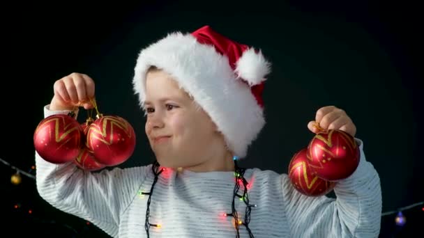 Niño Feliz Años Sombrero Santa Divierte Con Bolas Rojas Navidad — Vídeo de stock