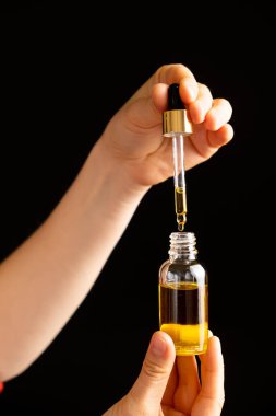 Kirpiklerin bakımı için doğal yağ, kaşlar, yüz derisi cam bir kavanoz pipete damlıyor..