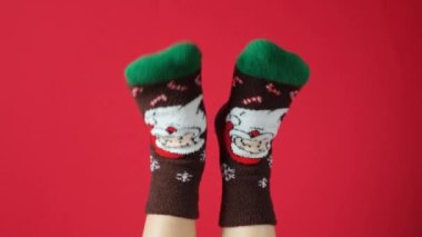 Noel çorabı giymiş kadınlar, kırmızı arka planda Noel Baba, dans eden bacaklar..